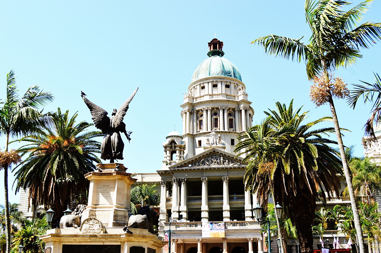 Durban City Hall with palm trees and a war memorial statue in front