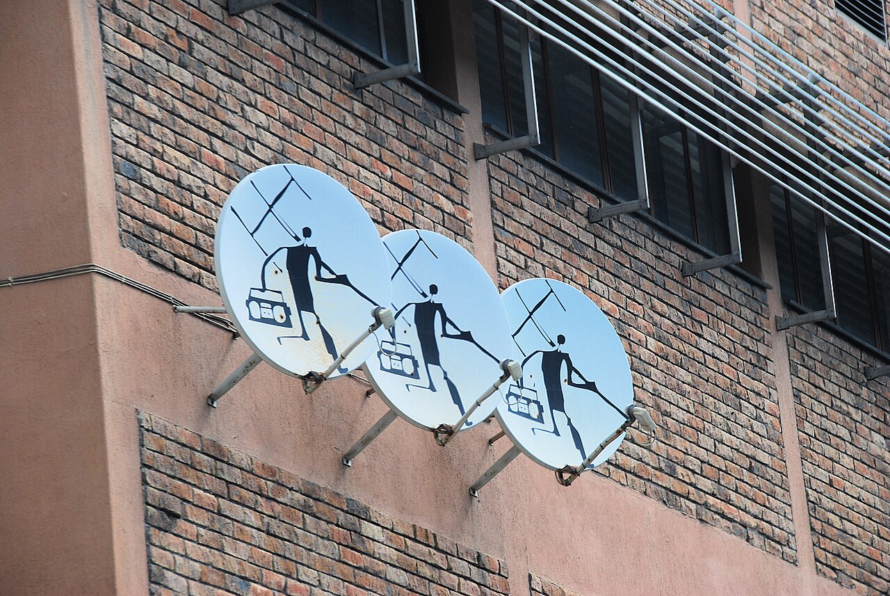 Three satellite dishes mounted on a brick building in Cape Town